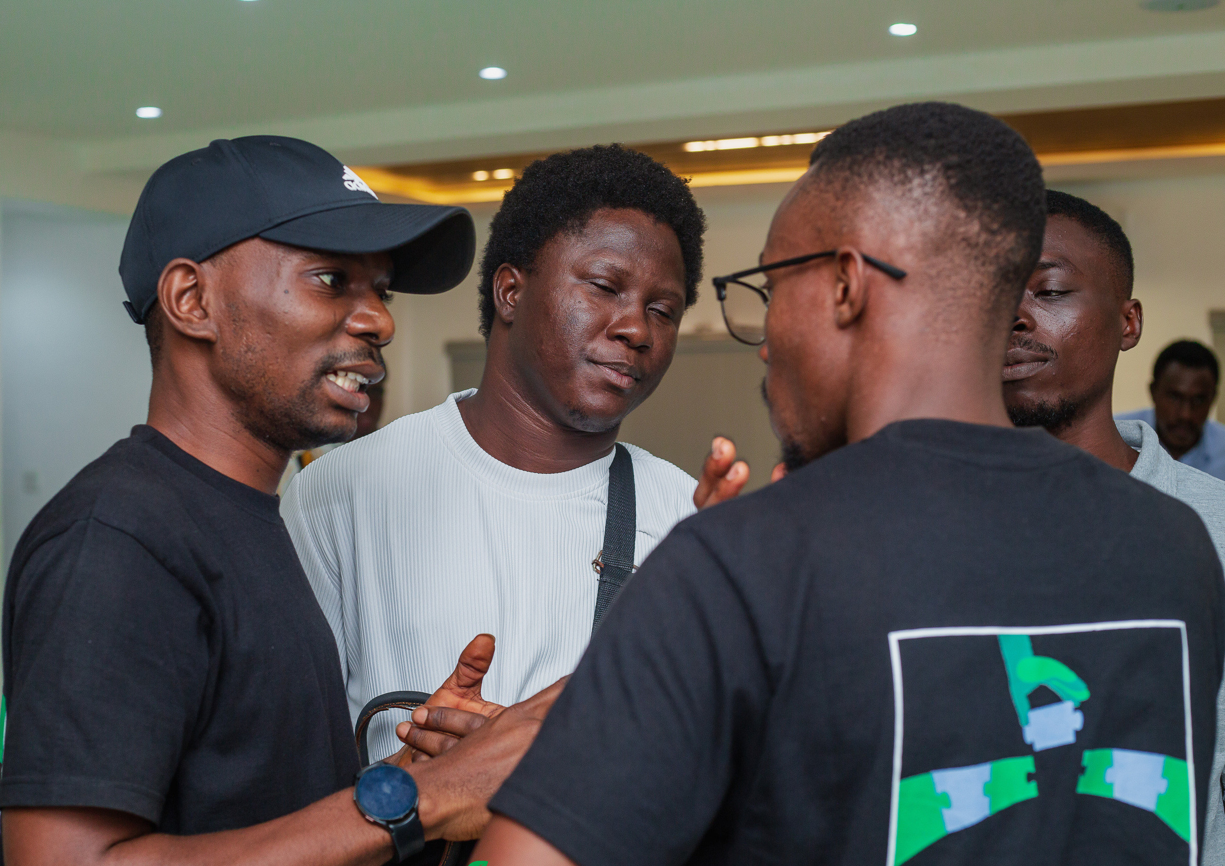 A group of participants talking together during a break, one in a JustUsedTech shirt.