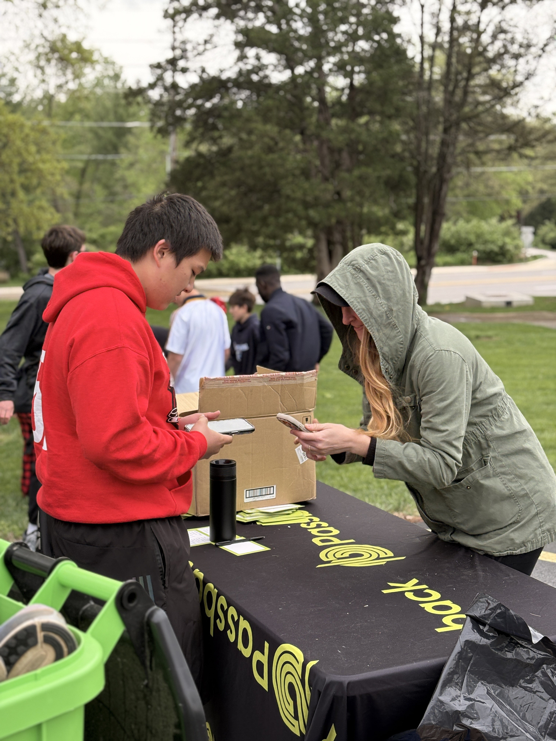 Two people packing a box at an outdoor collection table.