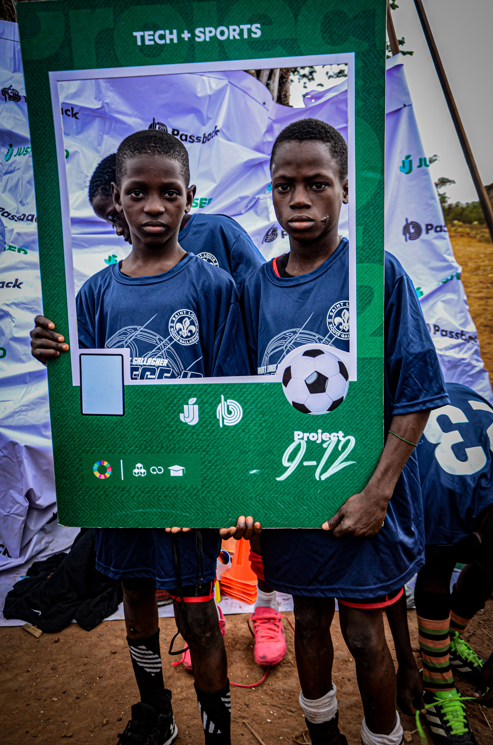 Two young players in team kit holding a Project 9-12 photo frame.